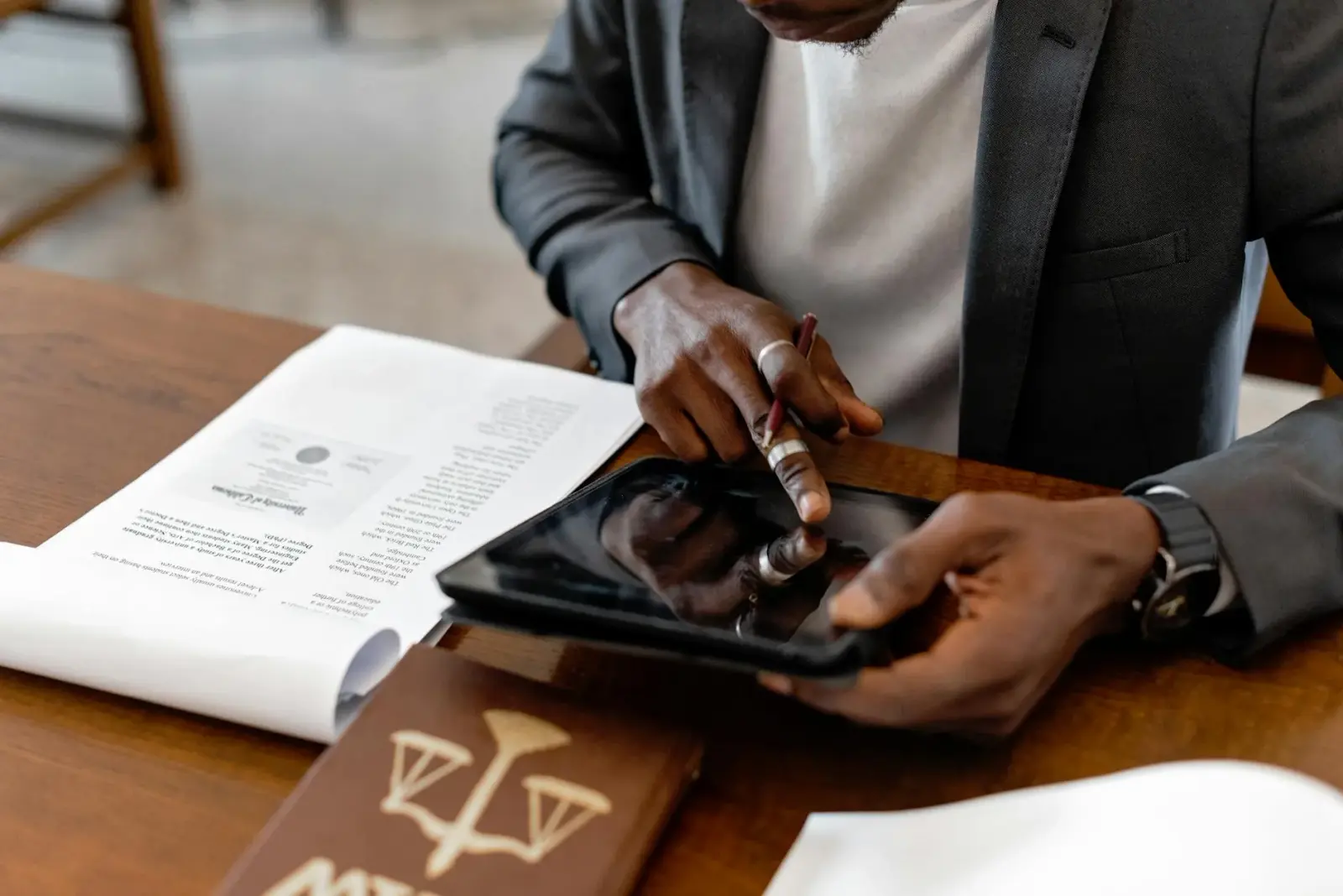 Close-up of a student's hands creating digital flashcards on a tablet at a messy dorm desk