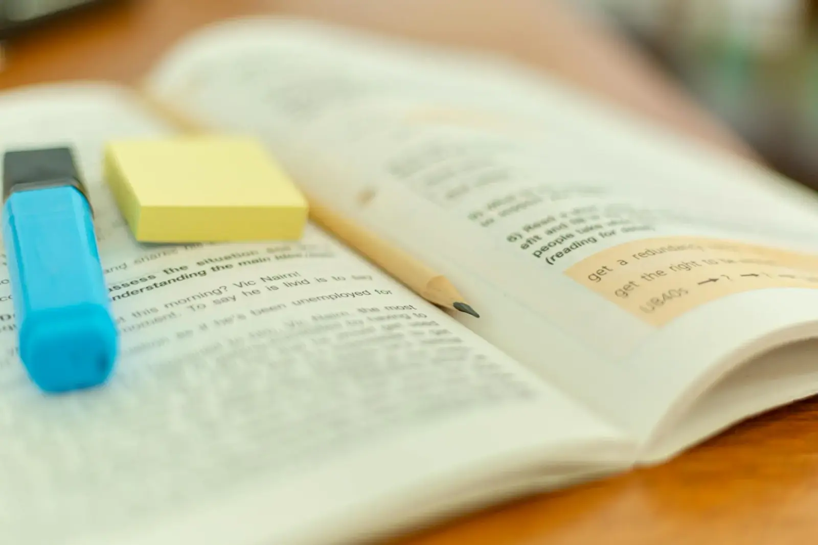 Close-up of hands highlighting notes in a Series 7 textbook on a messy desk.